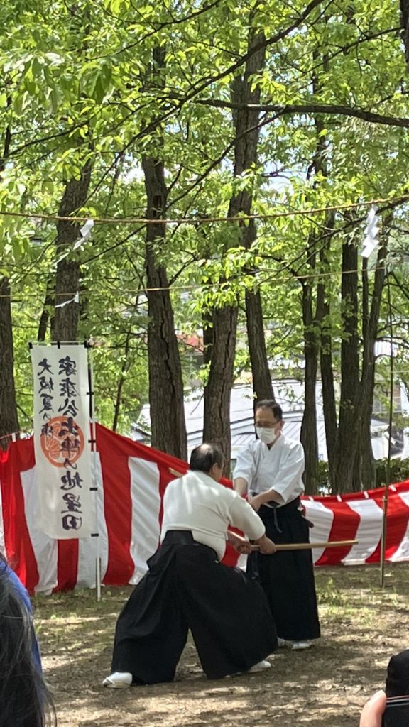 白袴姿の2人の人物が木刀を用いて演舞をしている